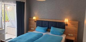 a bedroom with two beds with blue pillows at Apartmenthaus "Zum Löwen" Heidelberg - Ziegelhausen in Heidelberg