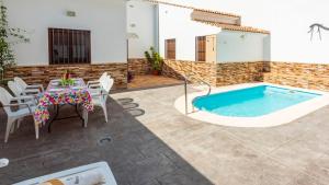 a patio with a table and a swimming pool at Casa Rural Sierra de las Nieves Yunquera by Ruralidays in Yunquera