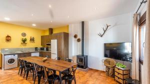 a kitchen and dining room with a wooden table and chairs at Casa Rural Sierra de las Nieves Yunquera by Ruralidays in Yunquera