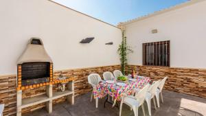 a patio with a table and a fireplace at Casa Rural Sierra de las Nieves Yunquera by Ruralidays in Yunquera