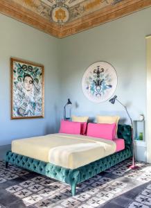 ein Schlafzimmer mit einem großen Bett mit rosa Kissen in der Unterkunft Castle Elvira in Trepuzzi