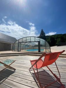 een rode stoel bovenop een houten terras bij Hotel Le Chalet in Sainte-Marie-de-Campan