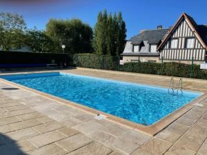 a swimming pool in front of a house at La Vigie spacieux, lumineux, piscine in Deauville