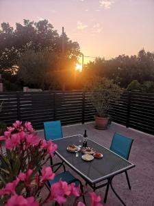 una mesa con comida y una botella de vino en el patio en Lennida Studio Apartman, en Kavran