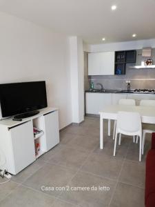 a living room with a table and a kitchen at Fascino del Cilento in Caprioli
