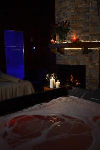 a living room with a fireplace and a table with candles at Mini spa in chalet bosco in Cisternino