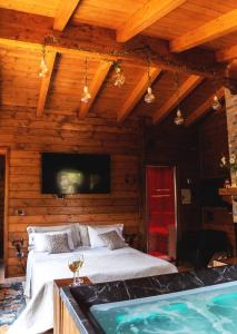 Mini spa in chalet bosco في تْشيستيرنِنو: غرفة نوم بسرير كبير وحوض استحمام