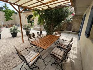 einen Holztisch und Stühle auf einer Terrasse in der Unterkunft Le Mas de la Vinçane in Pernes-les-Fontaines