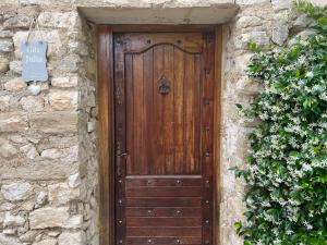 eine Holztür in einem Steingebäude mit einem Schild in der Unterkunft Le Mas de la Vinçane in Pernes-les-Fontaines