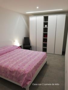 a bedroom with a pink bed and a chair at Fascino del Cilento in Caprioli