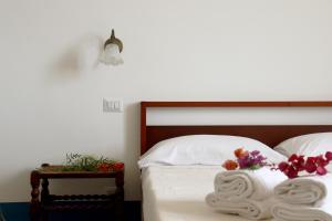 a bed with white sheets and flowers on it at Agriturismo Morani in Santa Severa