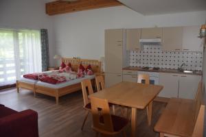 a room with a bed and a table and a kitchen at Landhaus Linser in Tarrenz