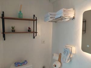 a bathroom with a toilet and towels on a wall at BAROS VIEW in Apérathos +45 photos