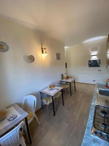 una habitación con mesas y sillas y una cocina en B&B My Home, en Agrigento
