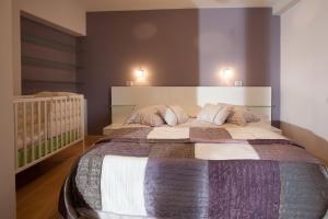 a bedroom with a large bed and a baby crib at Apartments Glusac in Podgora