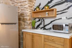 uma cozinha com um lavatório e um micro-ondas em מלכה בעתיקה em Safed