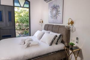 Un dormitorio con una cama con almohadas blancas y una ventana en מלכה בעתיקה en Safed