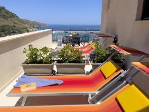卡斯泰拉姆馬雷德爾戈爾福的住宿－Sicilia Ovest - Sea View Terrace Dolce Vita，背景海洋的阳台上的一排桌子