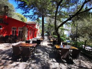 una fila de mesas y sillas frente a un edificio rojo en Morski gaj Resort, en Piran