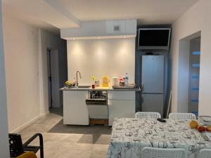 a kitchen with a table and a kitchen with a refrigerator at Guest House Ustka in Ustka