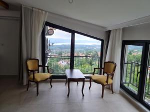 a room with a table and chairs and a large window at KD Apartments in Kartepe