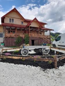 una casa con un coche aparcado delante de ella en Cabana Dor de-Acas / Restaurant Dor de-Acas en Gura Haitii