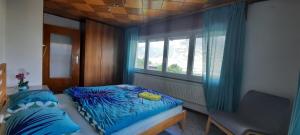 een slaapkamer met een bed met blauwe lakens en een raam bij Grand appartement 6 personnes, surf, ski et randonnées in Nendaz