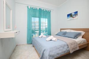 a bedroom with a bed with two towels on it at Blue Deluxe Apartment in Kallithea Halkidikis +13 photos