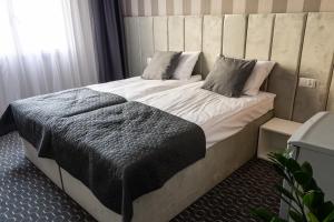 1 dormitorio con 1 cama grande y cabecero de madera en Pensjonat Dana, en Dziwnów
