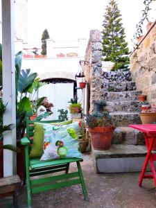 a green chair with a pillow on a patio at Masseria delle Rose 1760 in Alessano