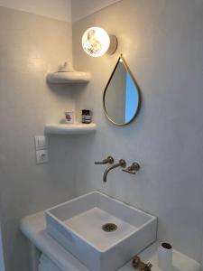 Un baño blanco con lavabo y espejo. en Villa Louloudia stylish luxury villa with private pool, en Pitsidia 15 fotos más