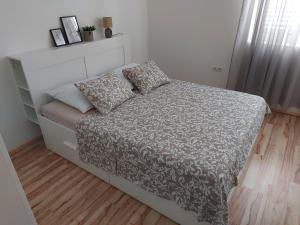 a small bedroom with a bed with a gray and white comforter at Vita Style in Kaštela