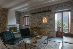 a living room with a stone wall at Manifest Boutique Hotel in Oitylo