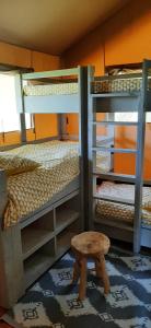 Cette chambre comprend 2 lits superposés et un tabouret. dans l'établissement Safaritent Lodge 5, à Ruurlo