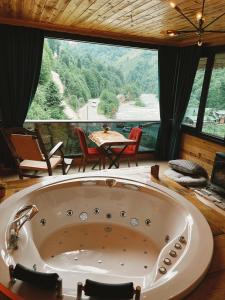 a bath tub in a room with a large window at Kiana Bungalov in Ardeşen