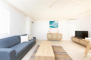 a living room with a blue couch and a tv at Camelot Unit 12 in Forster