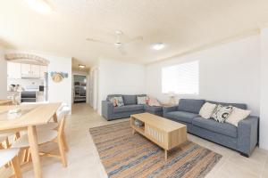 a living room with two blue couches and a table at Camelot Unit 12 in Forster