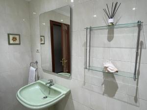 ein Bad mit einem Waschbecken und einem Spiegel in der Unterkunft Apartamento A Tenencia in Sada