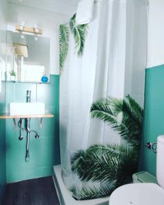 a bathroom with a sink and a shower curtain at Pensión Playa in Puerto de Mogán