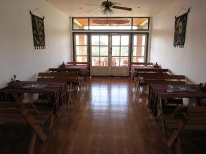 a room with tables and chairs and a ceiling fan at The Hillside Residence in Muang Phônsavan