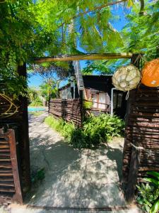 einen Eingang zu einem Haus mit einem Zaun und Bäumen in der Unterkunft Occi Lodge in Sodwana Bay