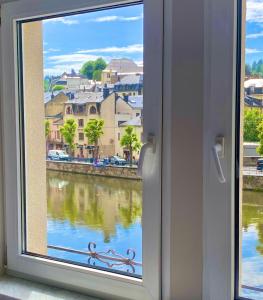 okno z widokiem na rzekę w obiekcie Hotel LA PLAGE w mieście Bouillon