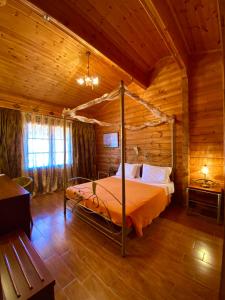 Dormitorio con cama con dosel en una cabaña de madera en Vigla Ias, en Neos Marmaras