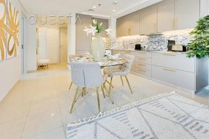 eine Küche mit einem Tisch mit Stühlen und einer Vase in der Unterkunft Bay Central, Dubai Marina in Dubai + 37 Fotos