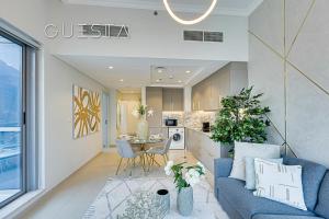 a living room with a blue couch and a kitchen at Bay Central, Dubai Marina in Dubai