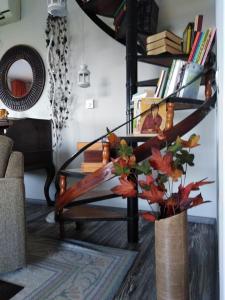 a spiral staircase in a living room with books at Το σπίτι με τα έλατα 