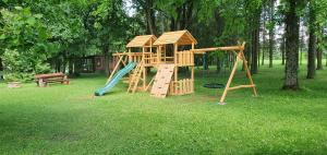 a park with a playground with a slide and a bench at Kaimo turizmo sodyba "Puozo Sodyba" in Puožas