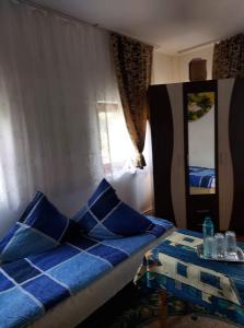 a bedroom with a bed with blue pillows and a table at Casa Rodica in Vatra Dornei