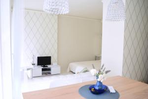 a room with a bed and a table with a tv at Cloé Apartman in Szeged