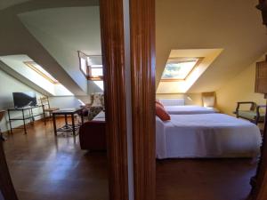 a bedroom with a bed and skylights in the ceiling at Apartamentos Mazuga Rural in Po